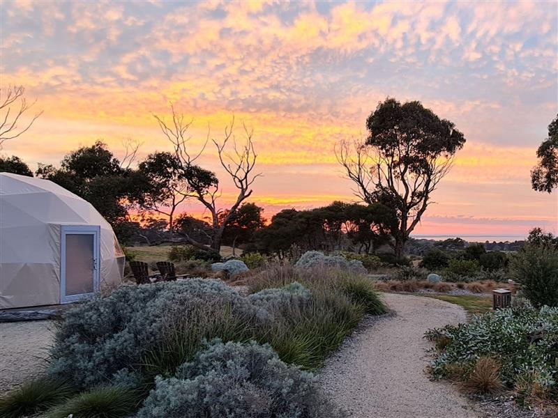 Sunrise over the ocean, unique dome type tent structure.