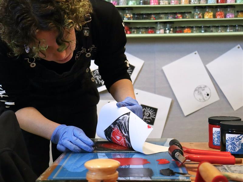 A student checking a two colour print in the printmaking workshop