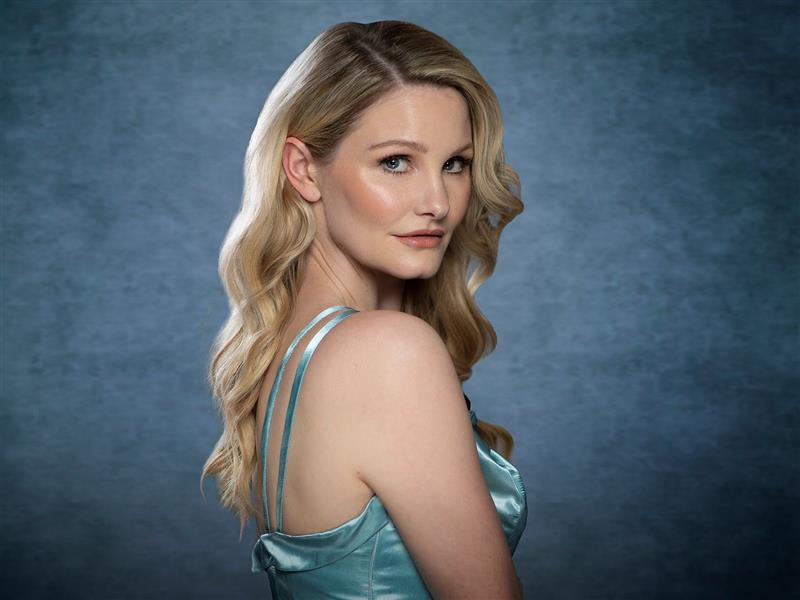 Cabaret artist Isabella Valette in costume, looking at the camera over her shoulder.